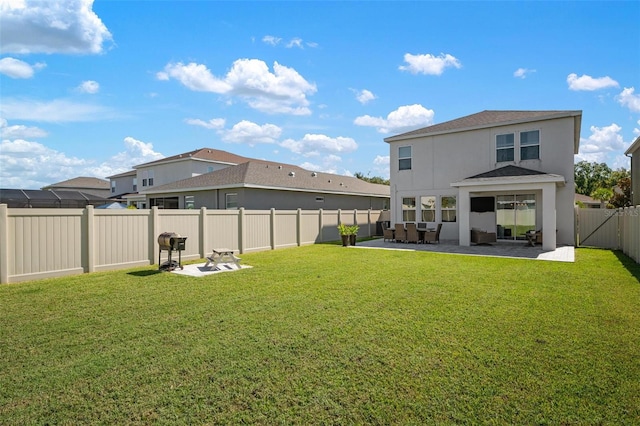 rear view of house with a patio and a lawn