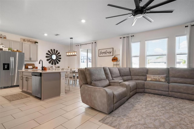 living room with ceiling fan and sink