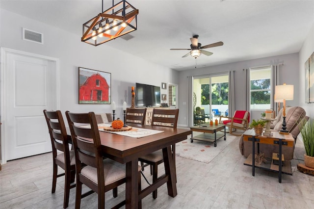 dining room featuring ceiling fan with notable chandelier