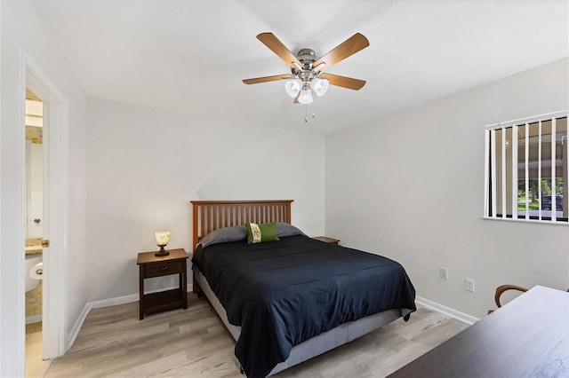 bedroom with light wood-type flooring, baseboards, ensuite bath, and a ceiling fan