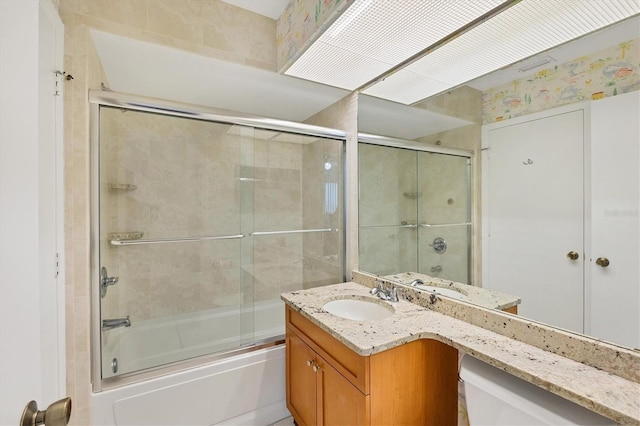 full bathroom with vanity and bath / shower combo with glass door