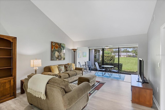 living room featuring light hardwood / wood-style floors and high vaulted ceiling