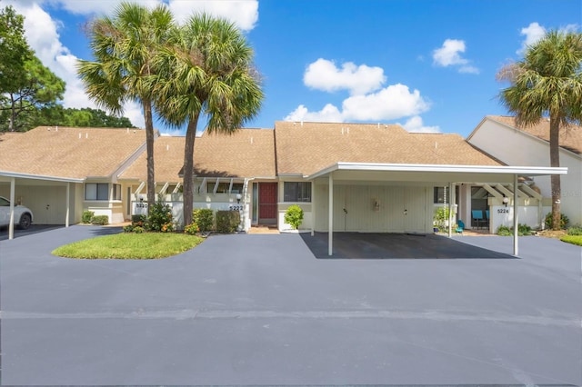 ranch-style home featuring a carport and aphalt driveway