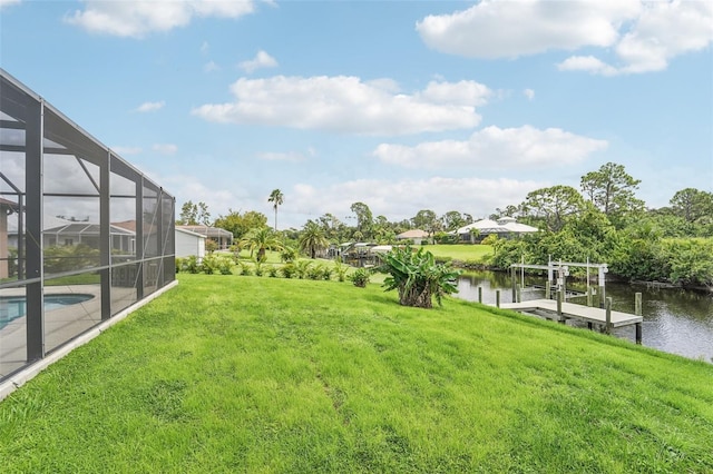 view of yard featuring glass enclosure, a water view, and a boat dock