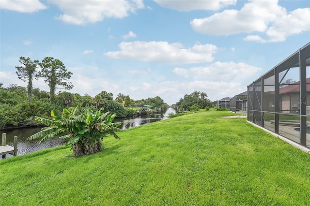 view of yard featuring a lanai and a water view