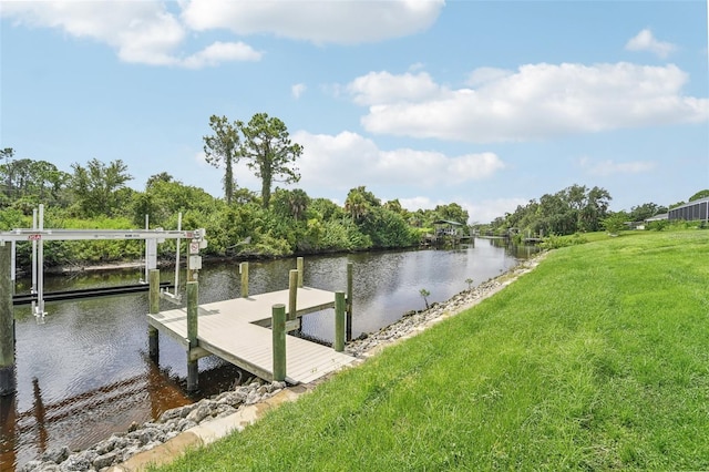 view of dock with a water view and a lawn