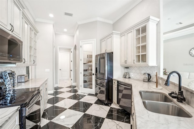 kitchen with black appliances, white cabinets, sink, decorative backsplash, and light stone countertops