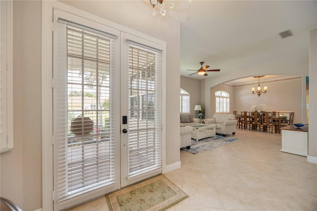 doorway to outside featuring ceiling fan with notable chandelier, french doors, plenty of natural light, and light tile patterned floors