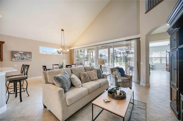 tiled living room with high vaulted ceiling and a chandelier