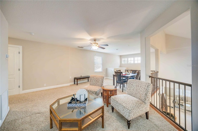 sitting room with a textured ceiling, carpet flooring, and ceiling fan