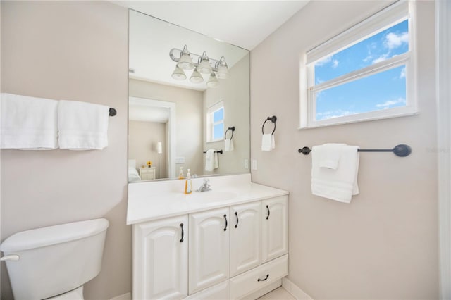 bathroom featuring vanity, toilet, and a healthy amount of sunlight