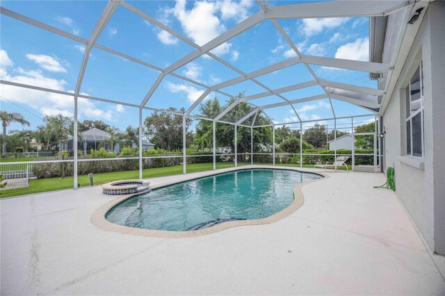 view of pool with glass enclosure and a patio area