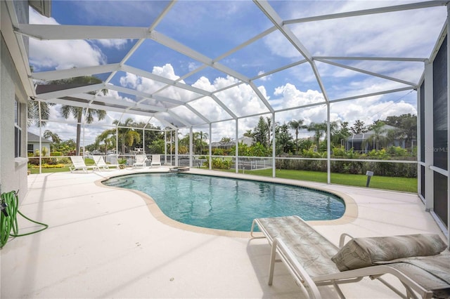 view of pool featuring glass enclosure and a patio