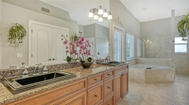 bathroom featuring a healthy amount of sunlight, vanity, and plus walk in shower