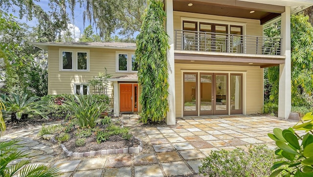 rear view of property featuring a balcony and a patio area