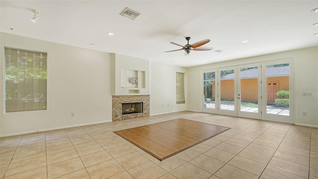 unfurnished living room with ceiling fan, light tile patterned floors, and french doors