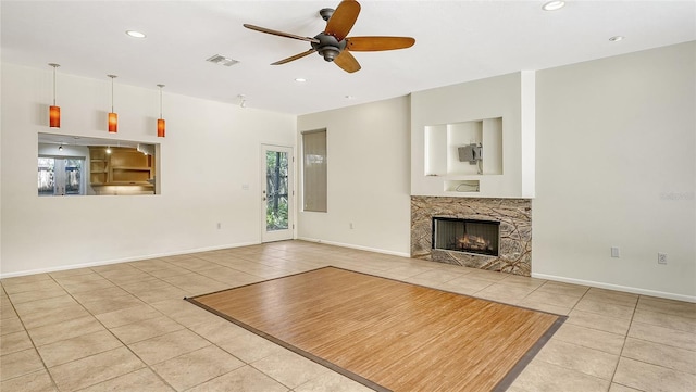 unfurnished living room featuring light tile patterned flooring and ceiling fan