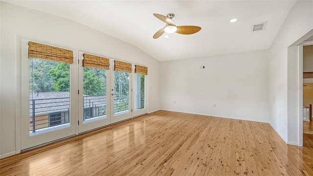 empty room with ceiling fan, light hardwood / wood-style floors, and vaulted ceiling