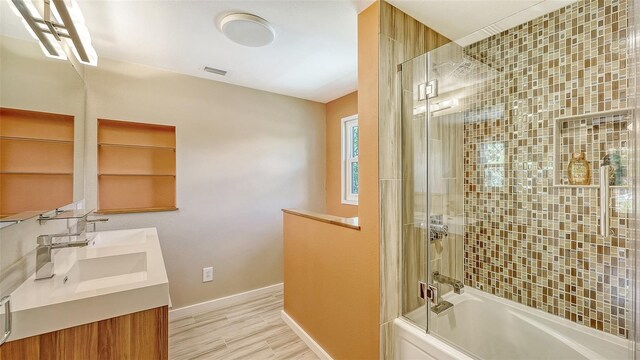 bathroom with vanity, hardwood / wood-style floors, and enclosed tub / shower combo