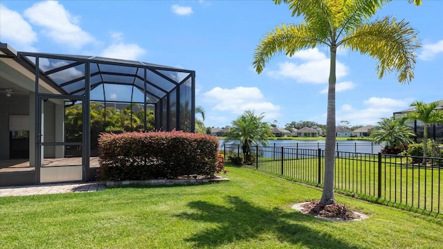 view of yard featuring glass enclosure and a water view