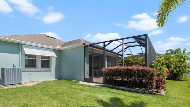 rear view of house featuring a lawn, a lanai, and central AC