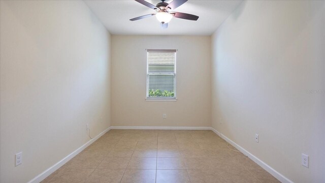 tiled empty room featuring ceiling fan