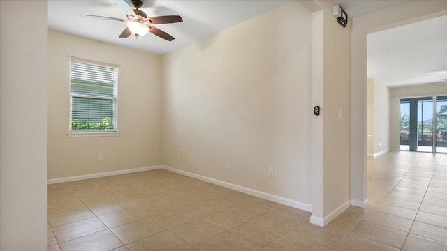 tiled spare room with ceiling fan