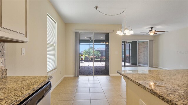 interior space featuring light tile patterned floors and ceiling fan with notable chandelier