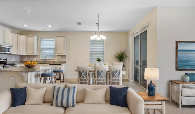 tiled living room featuring a notable chandelier