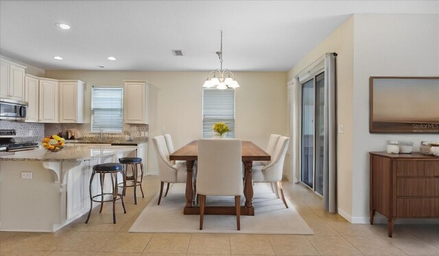 tiled dining space featuring a notable chandelier