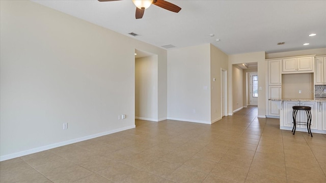 unfurnished living room featuring ceiling fan and light tile patterned flooring