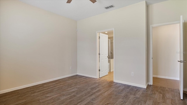 unfurnished bedroom with ceiling fan, connected bathroom, and dark hardwood / wood-style flooring