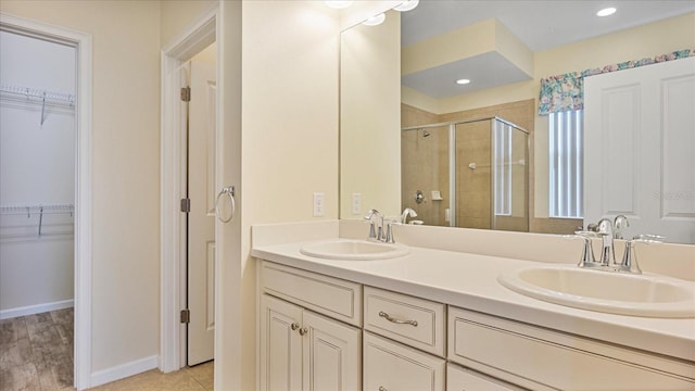 bathroom with vanity, hardwood / wood-style flooring, and a shower with shower door