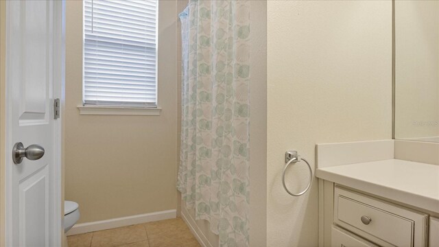 bathroom with tile patterned floors, toilet, curtained shower, and vanity