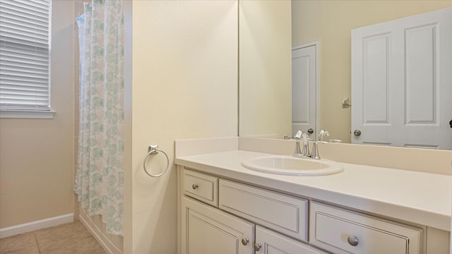 bathroom with tile patterned flooring, walk in shower, and vanity