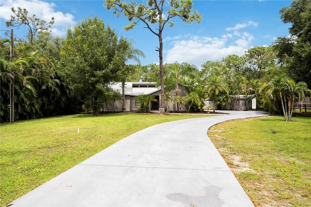 view of front facade featuring driveway and a front yard