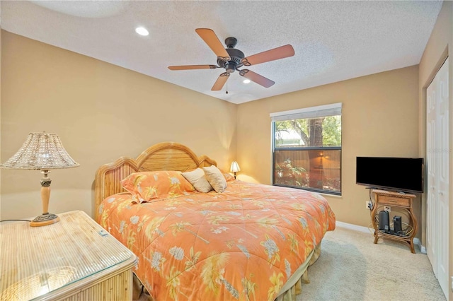 carpeted bedroom featuring a textured ceiling, ceiling fan, and a closet