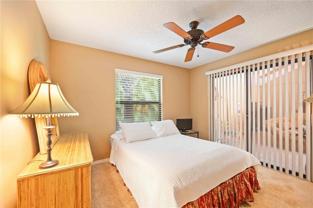 carpeted bedroom with a textured ceiling and ceiling fan