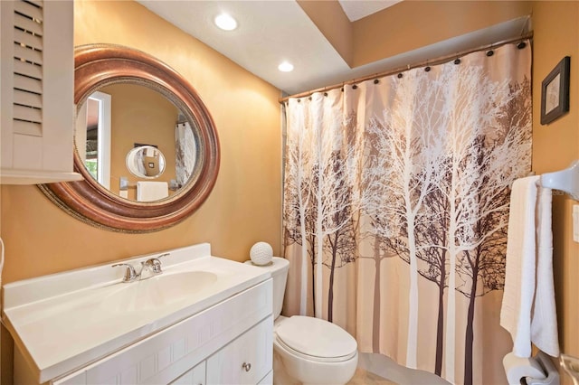 bathroom with walk in shower, toilet, and vanity