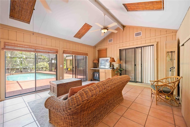 sunroom / solarium with ceiling fan and vaulted ceiling with beams