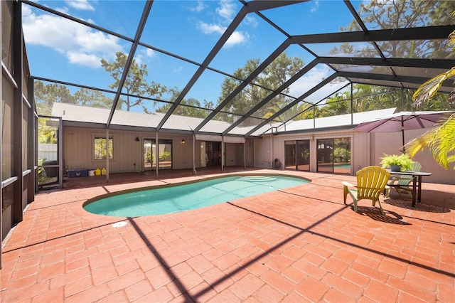 view of swimming pool with glass enclosure and a patio