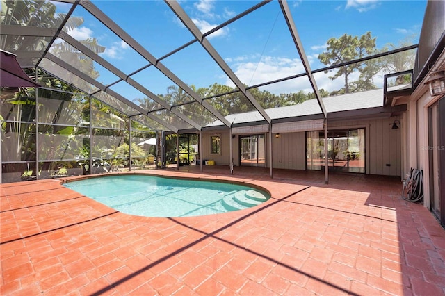 view of swimming pool featuring a patio and a lanai