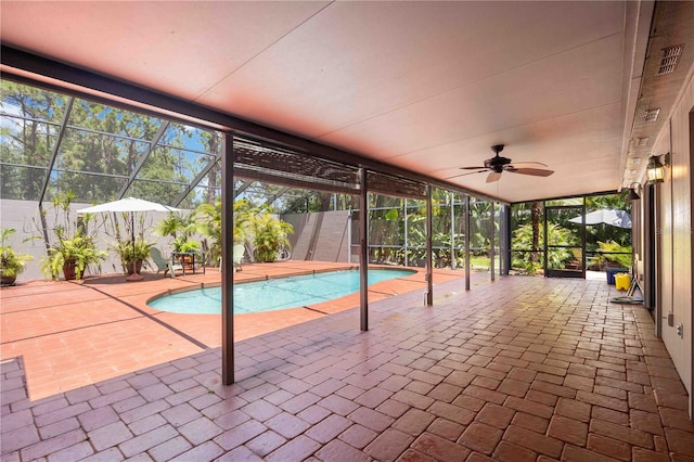 view of swimming pool featuring glass enclosure, ceiling fan, and a patio area