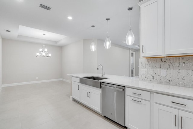 kitchen with a peninsula, a sink, decorative backsplash, dishwasher, and a tray ceiling