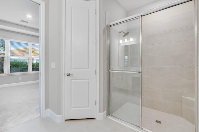 bathroom featuring a stall shower, tile patterned flooring, visible vents, and baseboards