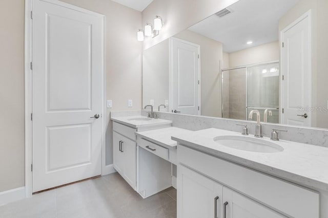 bathroom featuring double vanity, a stall shower, visible vents, and a sink