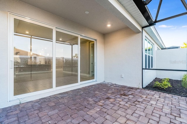 view of patio featuring glass enclosure