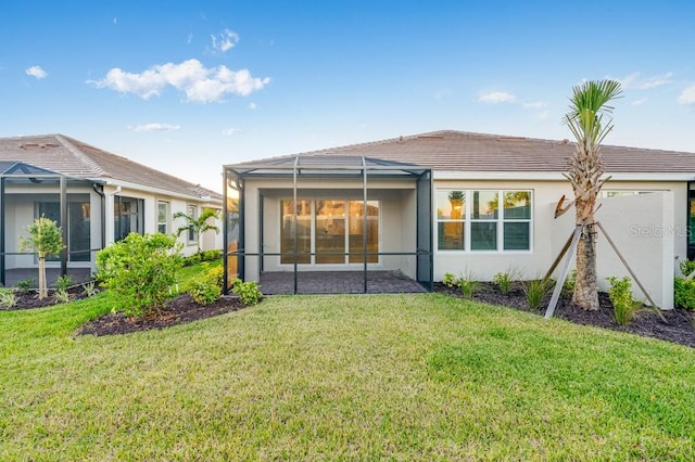 rear view of house featuring a lanai, a lawn, and stucco siding