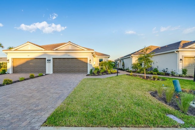 single story home with a front lawn, decorative driveway, an attached garage, and stucco siding