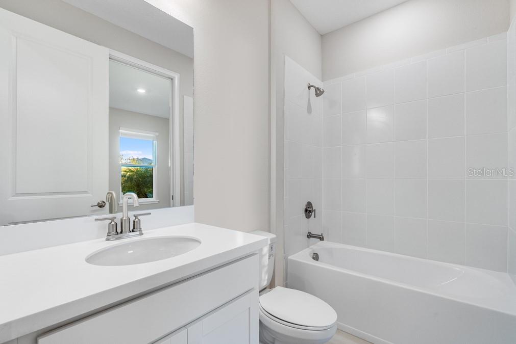 bathroom with toilet, bathtub / shower combination, and vanity